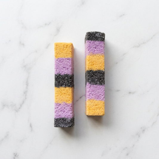 Yellow, purple and charcoal bath bars on light marble
